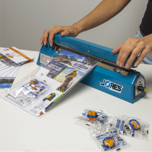 Persona usando la selladora manual por impulso de 12 pulgadas para cerrar una bolsa con un paquete promocional en su interior.
