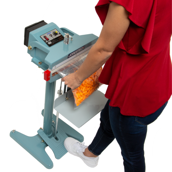 Una persona que lleva una camisa roja y jeans. Está sellando una bolsa grande con tapones para los oídos en su interior.