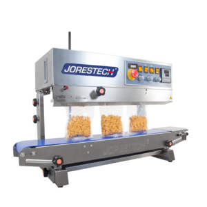 selladora continua de banda de acero inoxidable JORES TECHNOLOGIES® sellando varias bolsas de plástico llenas de galletas de naranja