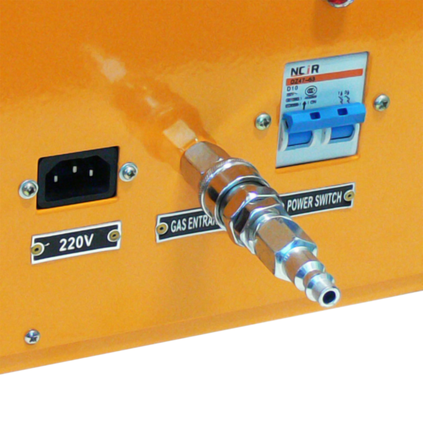 Primer plano de los siguientes detalles en una selladora de bolsas por impulso térmico: enchufe de alimentación de 220 V, conector de entrada de gas e interruptor de encendido.