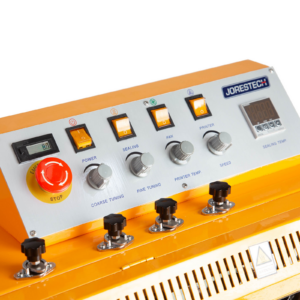 primer plano del panel de control de una selladora continua de banda JORES TECHNOLOGIES® amarilla con botón rojo de parada de emergencia y cuatro interruptores amarillos, y un regulador digital de temperatura de sellado.