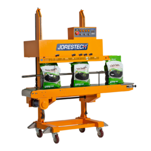 Selladora continua vertical amarilla JORES TECHNOLOGIES® con codificador, sellando una producción de grandes bolsas de plástico llenas de frijoles negros