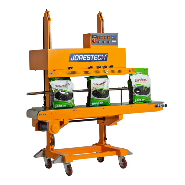 Selladora continua vertical amarilla JORES TECHNOLOGIES® con codificador, sellando una producción de grandes bolsas de plástico llenas de frijoles negros