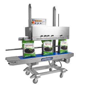 Selladora continua vertical de banda de acero inoxidable JORES TECHNOLOGIES® de izquierda a derecha con codificador para bolsas grandes. Sellado de una producción de bolsas termosellables de 5 lb llenas de frijoles negros