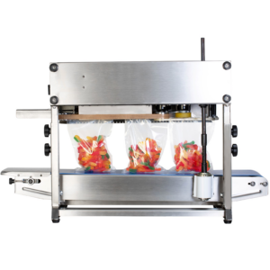 vista trasera de la máquina de sellado continuo JORES TECHNOLOGIES® de acero inoxidable sellando bolsas transparentes llenas de gusanos de goma multicolores vibrantes.