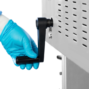 Operador con guantes azules ajustando la altura de la máquina de sellado con la manija negra desmontable antes de iniciar la producción