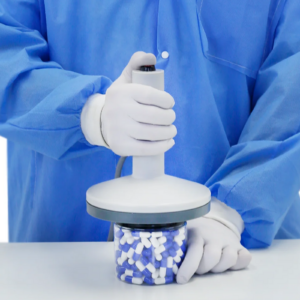 Persona colocando la cabeza del sellador de inducción manual sobre la tapa de plástico de un envase para sellarlo con un liner de inducción