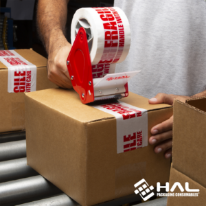hombre cerrando un gran número de cajas en una línea de producción usando el dispensador de cinta manual de alta resistencia HAL de 3 pulgadas