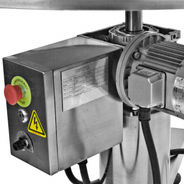 primer plano de la mesa de acumulación rotativa de acero inoxidable JORES TECHNOLOGIES® con botón rojo de parada de emergencia y etiqueta de advertencia amarilla