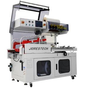 JORES TECHNOLOGIES® selladora automática de película en L. La selladora de film termorretráctil tiene la tapa de la cámara de sellado abierta para mostrar el mecanismo de sellado en L rojo. La máquina tiene un rollo de film termorretráctil transparente colocado en el dispensador.