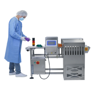 operador con mono protector azul y redecilla blanca colocando bolsas sobre el detector de metales automático JORES TECHNOLOGIES® de acero con cinta transportadora blanca