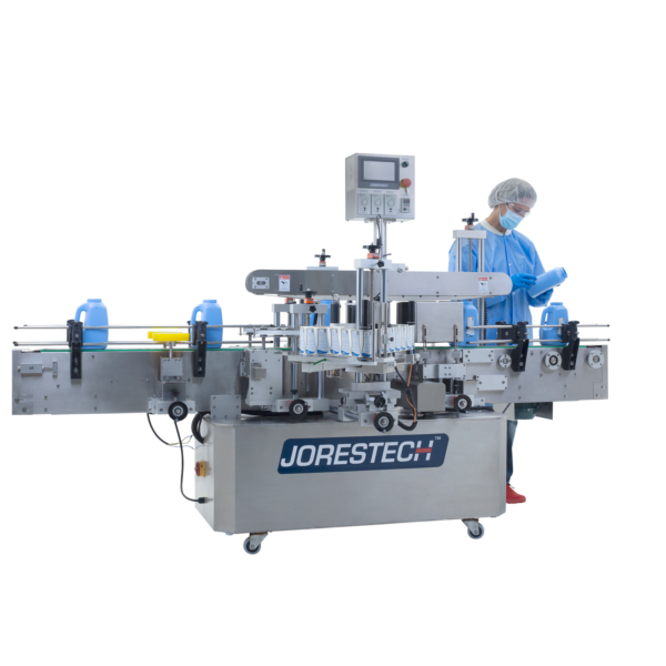 Trabajador con mono protector azul y redecilla para el cabello inspeccionando la etiqueta de una botella azul que sale de un aplicador automático doble de etiquetas de acero inoxidable para envases planos y ovalados