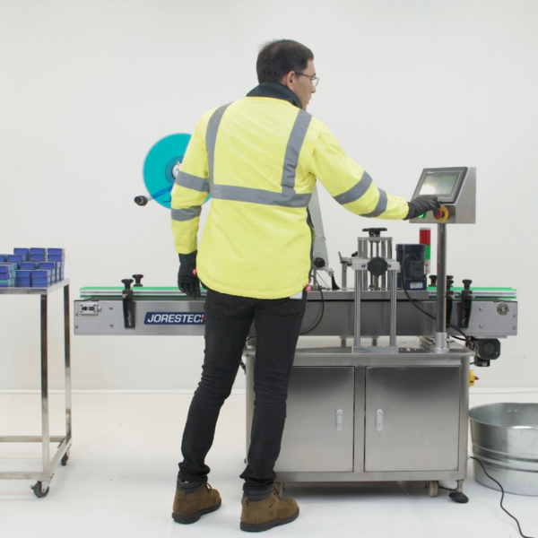 Una persona configurando el panel de control digital de la etiquetadora JORES TECHNOLOGIES® para envases planos.