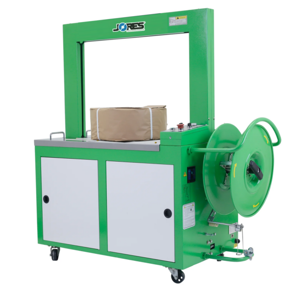 Una máquina automática de flejado de polipropileno JORES TECHNOLOGIES® verde y gris, con un rollo de fleje instalado en el dispensador. La máquina está flejando un artículo de forma cilíndrica
