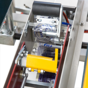 cinta adhesiva transparente girando alrededor de los rodillos dispensadores de la formadora automática de cajas con selladora de cinta inferior
