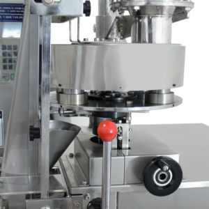 Primer plano detallado de la placa giratoria con vasos medidores volumétricos telescópicos en un sistema de envasado VFFS JORES TECHNOLOGIES®.