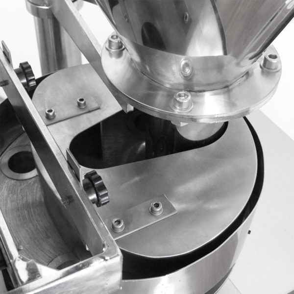 Parte de un sistema de envasado vertical VFFS de formado, llenado y sellado, donde se puede apreciar la tolva de alimentación de acero inoxidable junto con el disco giratorio y las tazas de medición volumétrica.