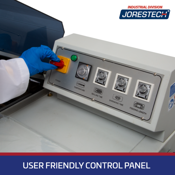 Primer plano detallado del panel de control de una Máquina de Envasado Retráctil tipo cámara JORES TECHNOLOGIES®. Una mano con guante azul está girando el interruptor de ENCENDIDO / APAGADO. El panel de control muestra perillas giratorias para el control de temperatura, el tiempo de sellado y el tiempo de retracción. Una franja azul dice: Panel de control fácil de usar.