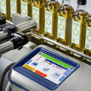 Codificador de inyección de tinta instalado como parte de una línea de producción de botellas de vidrio de aceite de oliva. Las botellas pasan frente al cabezal de impresión del codificador de inyección de tinta automático CIJ LINX 10