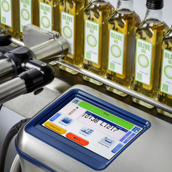Codificador de inyección de tinta instalado como parte de una línea de producción de botellas de vidrio de aceite de oliva. Las botellas pasan frente al cabezal de impresión del codificador de inyección de tinta automático CIJ LINX 10