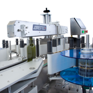 Primer plano del aplicador automático dual de etiquetas JORES TECHNOLOGIES® colocando 2 etiquetas al mismo tiempo en una serie de botellas de vidrio verdes y planas.