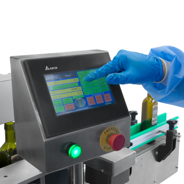 operario con guantes desechables de nitrilo azules usando el panel de control digital del aplicador automático doble de etiquetas JORES TECHNOLOGIES®