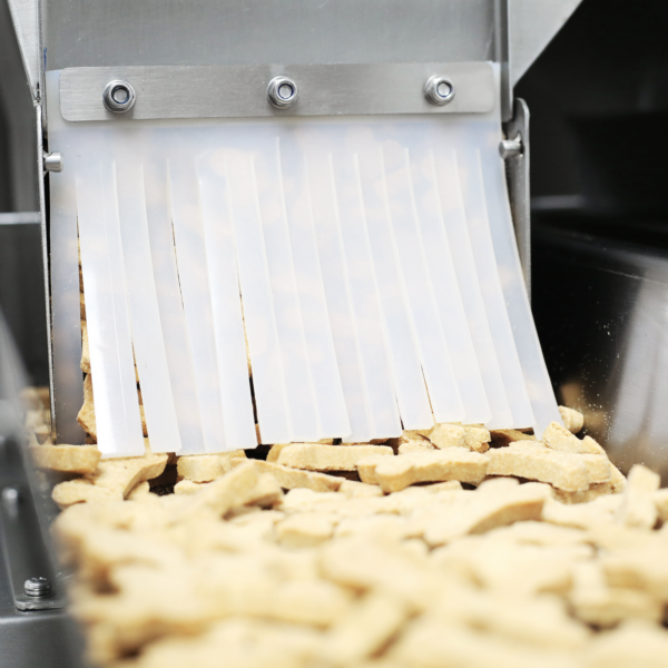 Vista de cerca de la pesadora lineal de doble cabezal de acero inoxidable JORES TECHNOLOGIES® para dosificación de galletas para perros de 4000 ml