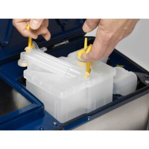 Persona insertando el kit de servicio de cambio fácil de una impresora de inyección de tinta LINX