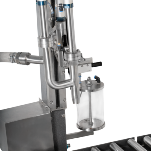 Primer plano que muestra la conexión de la manguera de succión y la boquilla de dispensación del llenador de peso neto para líquidos JORES TECHNOLOGIES®.