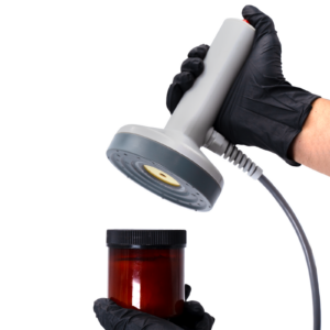 Trabajador sellando un recipiente de plástico con un liner de inducción usando una máquina selladora de inducción manual JORESTECH