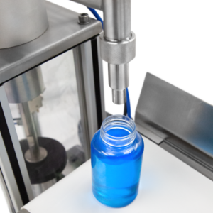 Primer plano que muestra la boquilla antigoteo de acero inoxidable sobre la botella transparente llena de líquido azul de alta viscosidad