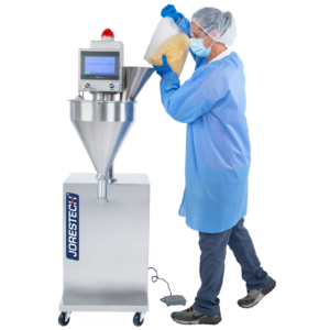 Primer plano de un trabajador con guantes de látex azules y equipo de protección personal (EPP) sosteniendo una bolsa transparente llena de harina de maíz. La bolsa se mantiene sobre el cono de alimentación de la llenadora de polvo por tornillo JORES TECHNOLOGIES®, que se utilizará para dispensar la harina en recipientes.