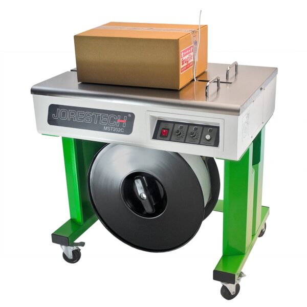 Una máquina flejadora semiautomática JORES TECHNOLOGIES® lista para flejar una caja de cartón ubicada en el área de trabajo de flejado de acero inoxidable