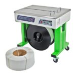 Una máquina flejadora semiautomática de gabinete abierto JORES TECHNOLOGIES® en color verde y gris, con un gran rollo de fleje de polietileno blanco instalado