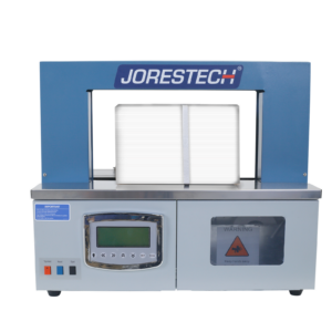 Vista frontal de una máquina de flejado JORES TECHNOLOGIES® ® gris y azul para papel y plástico. Se puede ver una caja blanca en el área de sellado con una banda blanca alrededor.