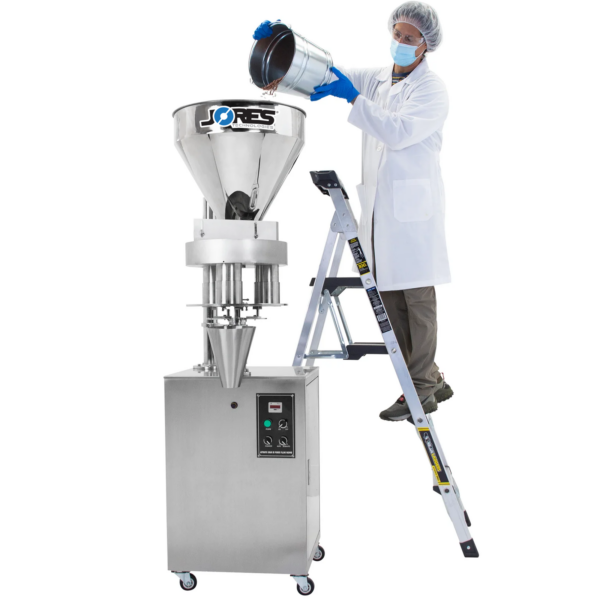 Trabajador de pie sobre una escalera vertiendo un cubo lleno de frijoles en la tolva de acero inoxidable de la llenadora volumétrica semiautomática JORES TECHNOLOGIES® de 1000 ml