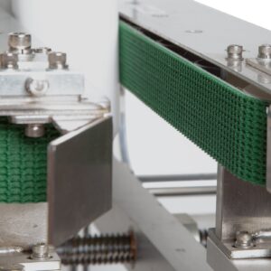Primer plano de las correas de tracción laterales verdes en la transportadora sin fondo de acero inoxidable JORES TECHNOLOGIES®