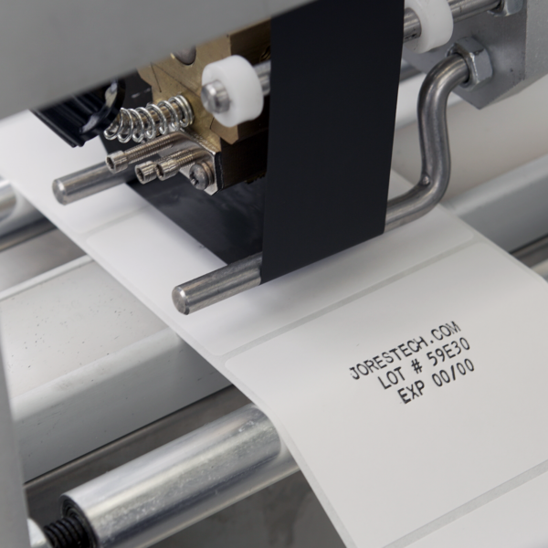 Impresora integrada y tinta negra de estampado en caliente en la aplicadora semiautomática de etiquetas para envases redondos de JORES TECHNOLOGIES®