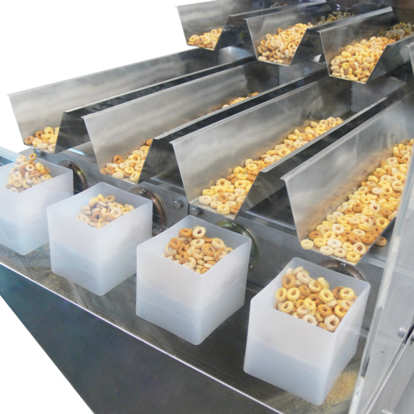 Primer plano de una pesadora lineal de cuatro cabezales JORES TECHNOLOGIES® midiendo y dosificando cereal en forma de O