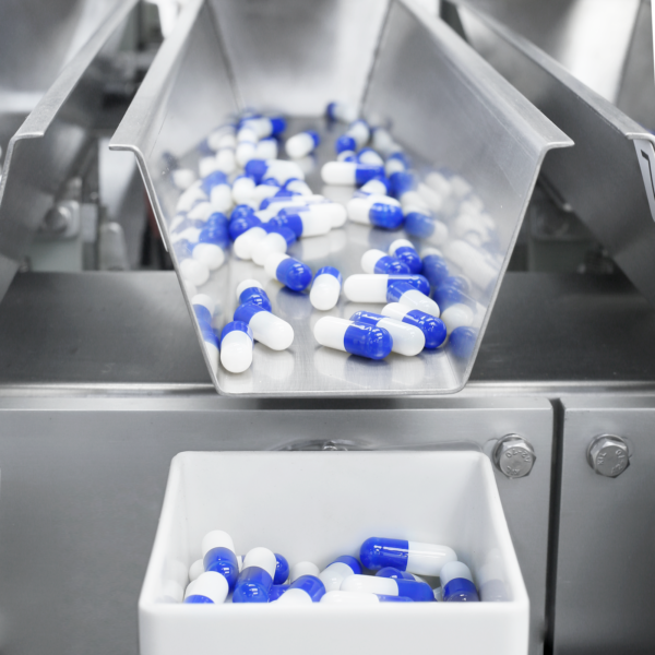 Primer plano de una pesadora lineal de cuatro cabezales JORES TECHNOLOGIES® midiendo y dispensando cápsulas