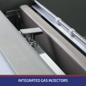 Primer plano del elemento de sellado y de las pinzas de sujeción de la bolsa y de inyección de gas en una máquina de envasado al vacío. Una banda azul en la parte inferior con texto blanco dice inyección de gas integrada