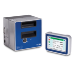 La impresora de transferencia térmica LINX TT500 para sobreimpresión en formato estrecho y el panel de control digital con pantalla táctil en el lado derecho. El panel de control digital está encendido y muestra la fecha de producción, la fecha de caducidad, la hora y otra información de lote que se va a imprimir.