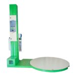 Vista lateral de una máquina de envoltura estirable para palés verde con una plataforma giratoria beige