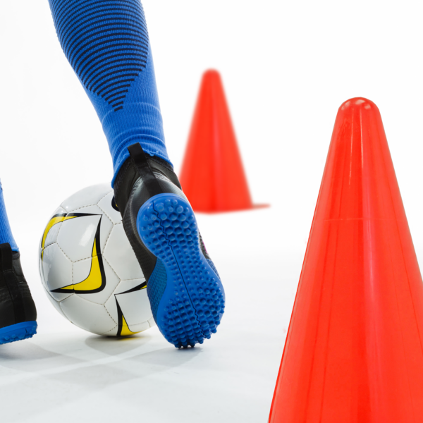 Una persona usando los conos de entrenamiento mientras practica fútbol