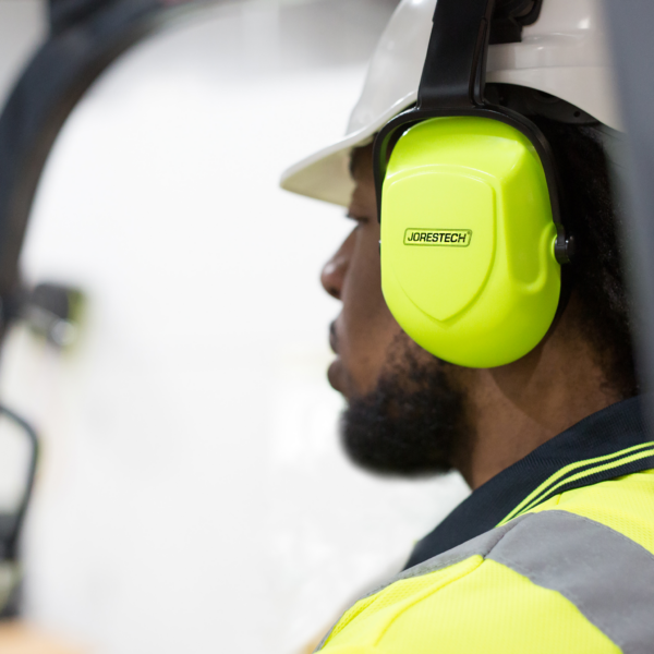 Un trabajador que lleva un casco blanco con orejeras JORESTECH con cancelación de ruido de color lima brillante instaladas