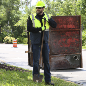 Hombre que lleva el chaleco de seguridad reflectante mientras está en una obra o reparación de carretera