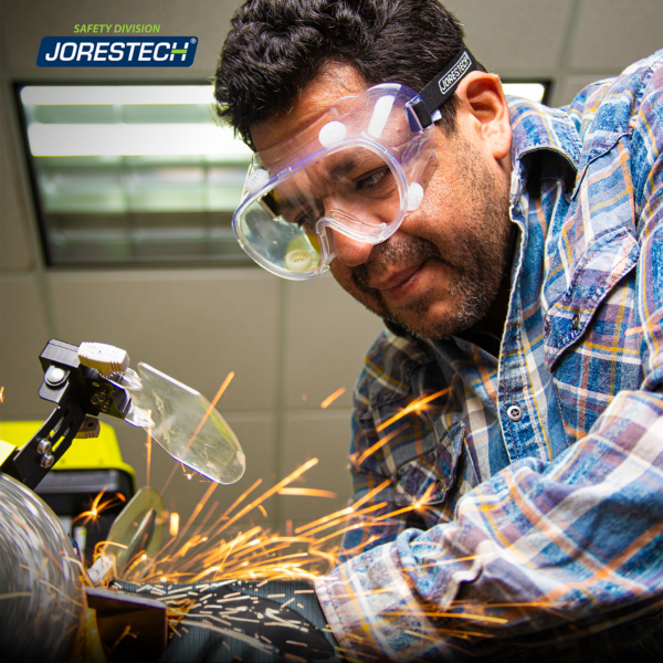 Hombre usando gafas de seguridad JORESTECH mientras opera una máquina con herramienta eléctrica