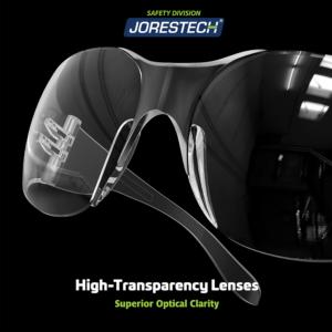 Primer plano de unas gafas de seguridad transparentes antivaho JORESTECH para protección contra alto impacto sobre fondo negro. Letras brillantes en verde y blanco dicen: lentes de alta transparencia para una claridad óptica superior