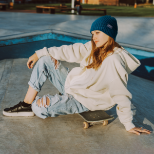 Mujer usando un gorro azul con costuras reflectantes para patinaje en línea