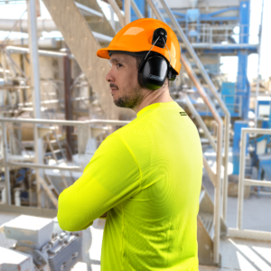 Trabajador que lleva un casco de seguridad estilo gorra con ranuras y protección auditiva